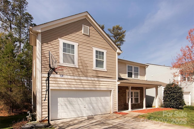 traditional-style house featuring a porch, concrete driveway, and a garage