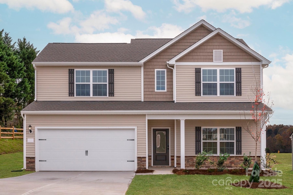 craftsman inspired home featuring fence, stone siding, driveway, a front lawn, and a garage