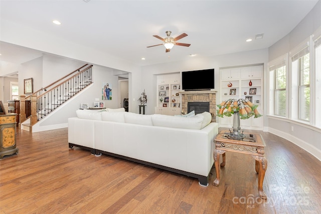 5706 Sardis Hall Ct, Charlotte, NC 28270 - living area with stairs, a brick fireplace, wood finished floors, baseboards, and ceiling fan