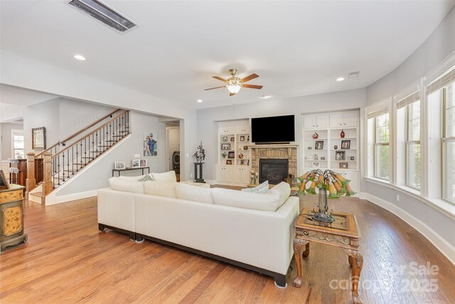 5706 Sardis Hall Ct, Charlotte, NC 28270 - living area with visible vents, a brick fireplace, wood finished floors, stairway, and a ceiling fan