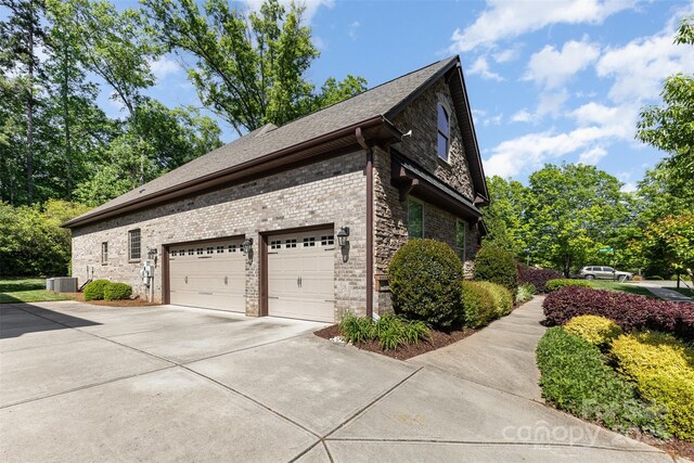 5706 Sardis Hall Ct, Charlotte, NC 28270 - view of side of home with a shingled roof, an attached garage, brick siding, central air condition unit, and driveway