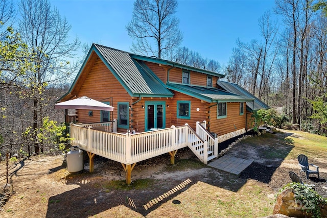 rear view of property featuring a standing seam roof, metal roof, log siding, and a deck