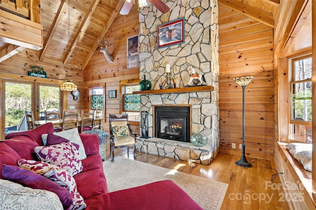 2245 Mckenzie Way N Unit 754, Old Fort, NC 28762 - living area featuring wood walls, a wood ceiling with exposed beams, wood finished floors, high vaulted ceiling, and a stone fireplace