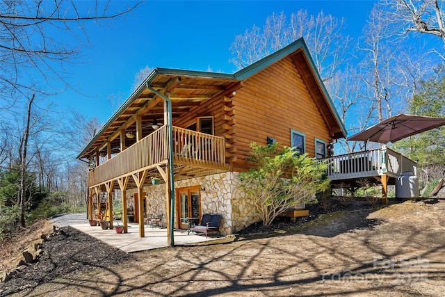 2245 Mckenzie Way N Unit 754, Old Fort, NC 28762 - rear view of house with stone siding, a deck, a patio area, log exterior, and ceiling fan