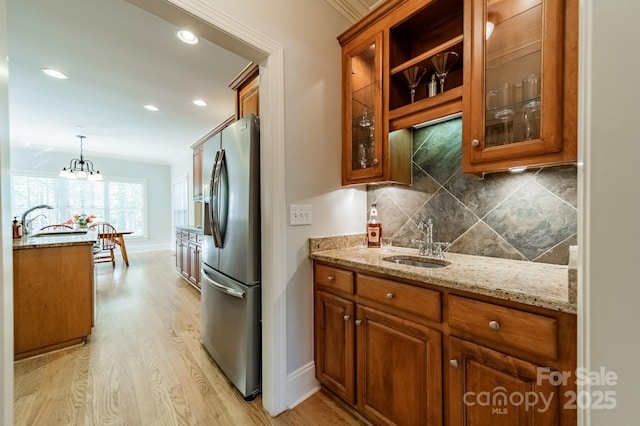 4599 Rustling Woods Dr, Denver, NC 28037 - kitchen with stainless steel fridge, brown cabinets, a sink, light wood-style flooring, and recessed lighting