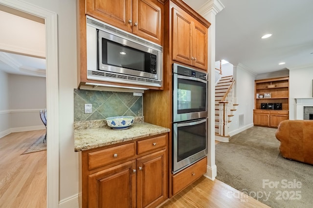 4599 Rustling Woods Dr, Denver, NC 28037 - kitchen featuring stainless steel appliances, baseboards, ornamental molding, tasteful backsplash, and light stone counters