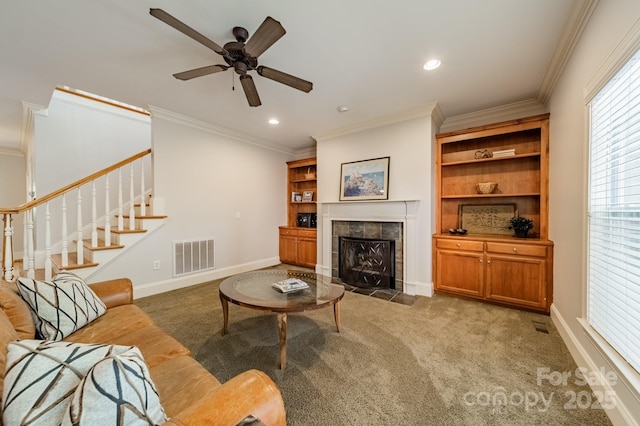 4599 Rustling Woods Dr, Denver, NC 28037 - living room featuring crown molding, a tiled fireplace, light colored carpet, a ceiling fan, and stairway