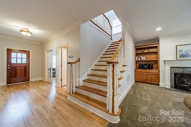 4599 Rustling Woods Dr, Denver, NC 28037 - foyer entrance featuring crown molding, stairs, a tiled fireplace, baseboards, and light wood-style floors