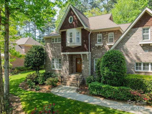 4599 Rustling Woods Dr, Denver, NC 28037 - shingle-style home with a front yard, a shingled roof, and brick siding