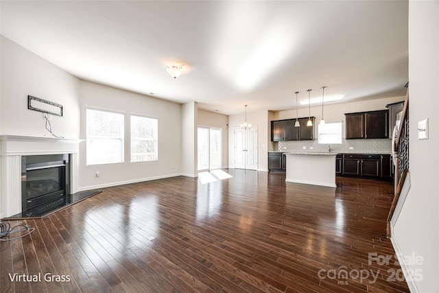 1929 Shorthorn St, Charlotte, NC 28213 - unfurnished living room featuring plenty of natural light, a glass covered fireplace, and dark wood-style flooring