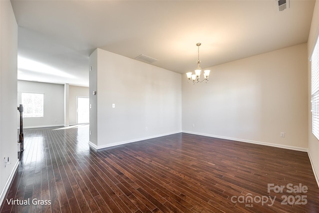 1929 Shorthorn St, Charlotte, NC 28213 - unfurnished room featuring baseboards, dark wood-style flooring, visible vents, and a notable chandelier