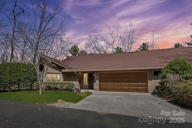 mid-century modern home featuring a lawn, aphalt driveway, a garage, and stone siding