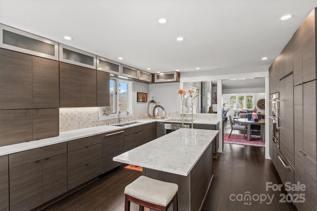 kitchen featuring a sink, modern cabinets, dark wood-style floors, and glass insert cabinets