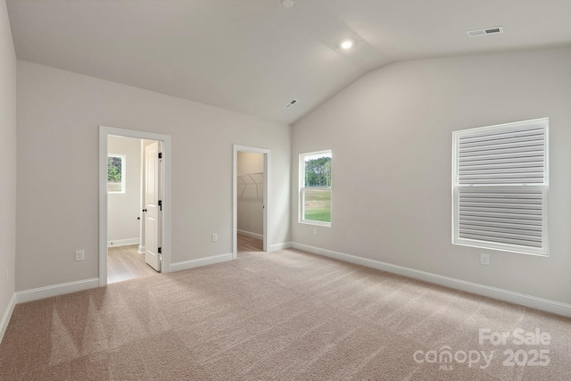 7015 Jerimoth Dr, Charlotte, NC 28215 - unfurnished bedroom featuring light carpet, a walk in closet, lofted ceiling, baseboards, and a closet
