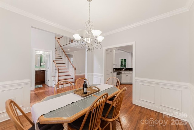 6414 Winding Creek Ln, Denver, NC 28037 - dining area featuring a chandelier, ornamental molding, stairway, wood finished floors, and a wainscoted wall