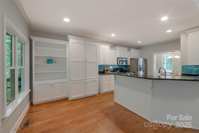 6414 Winding Creek Ln, Denver, NC 28037 - kitchen with appliances with stainless steel finishes, white cabinets, ornamental molding, tasteful backsplash, and light wood-style flooring