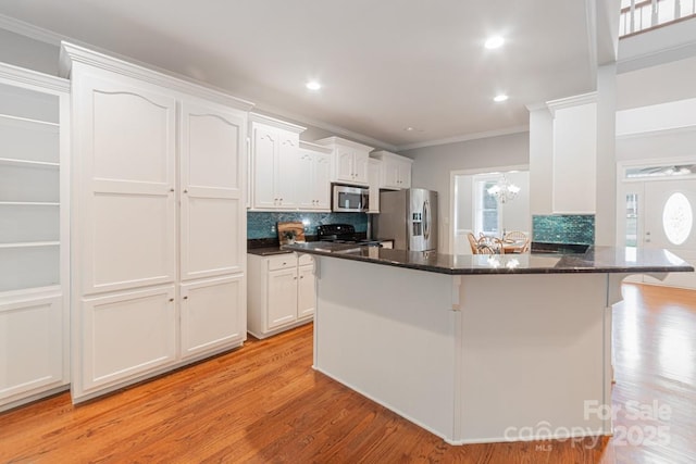 6414 Winding Creek Ln, Denver, NC 28037 - kitchen with stainless steel appliances, crown molding, white cabinetry, a breakfast bar area, and backsplash