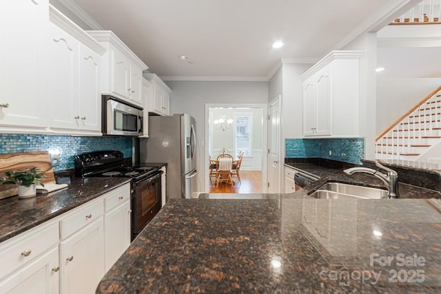 6414 Winding Creek Ln, Denver, NC 28037 - kitchen featuring appliances with stainless steel finishes, a sink, white cabinets, dark stone counters, and ornamental molding
