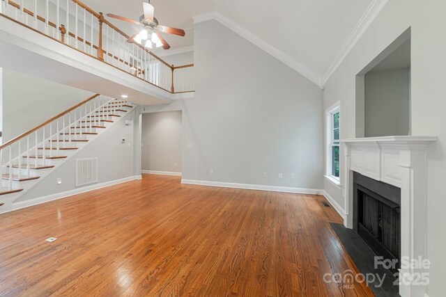 6414 Winding Creek Ln, Denver, NC 28037 - unfurnished living room with ornamental molding, ceiling fan, stairway, a fireplace with flush hearth, and baseboards