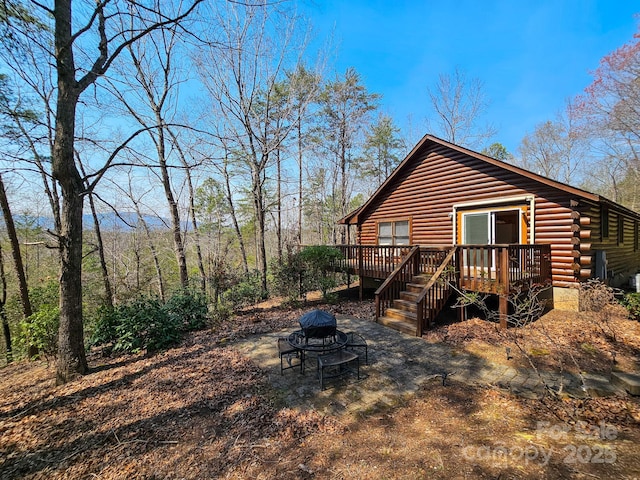 view of home's exterior featuring an outdoor fire pit, a deck, and stairs