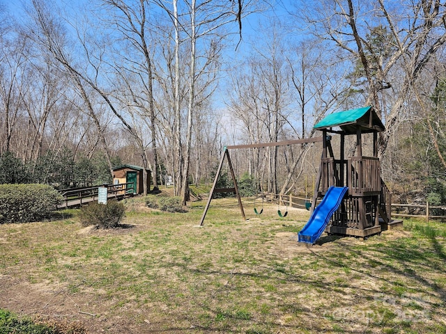 view of yard with fence, an outdoor structure, and a playground