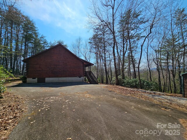 view of side of home featuring driveway and crawl space