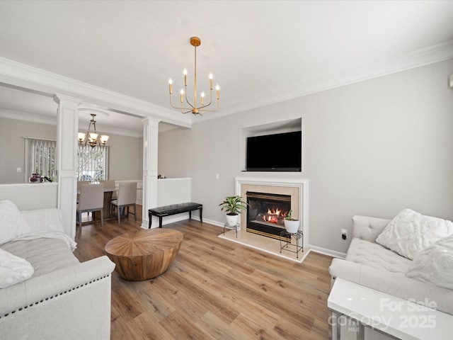 14802 Rolling Sky Dr, Charlotte, NC 28273 - living room featuring decorative columns, a notable chandelier, a fireplace, light wood-style flooring, and baseboards