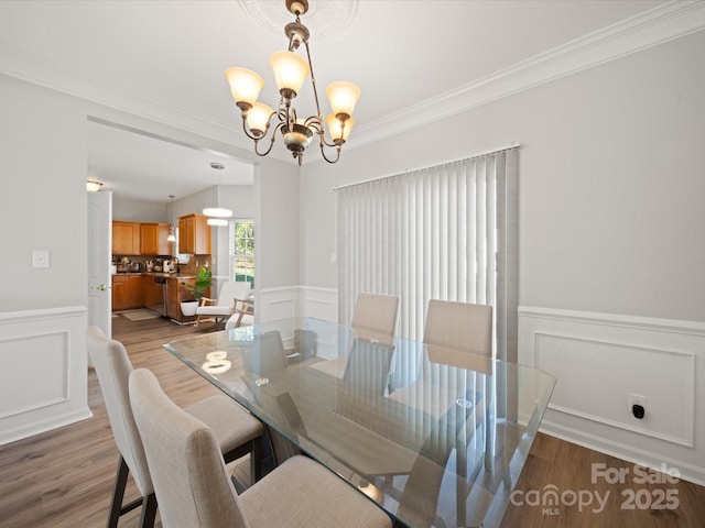 14802 Rolling Sky Dr, Charlotte, NC 28273 - dining space with wood finished floors, a chandelier, crown molding, and wainscoting