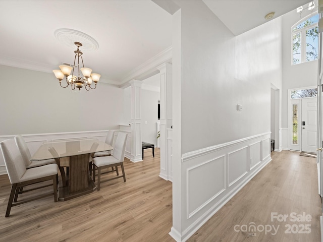 14802 Rolling Sky Dr, Charlotte, NC 28273 - dining space featuring a notable chandelier, light wood-style floors, a decorative wall, and ornamental molding