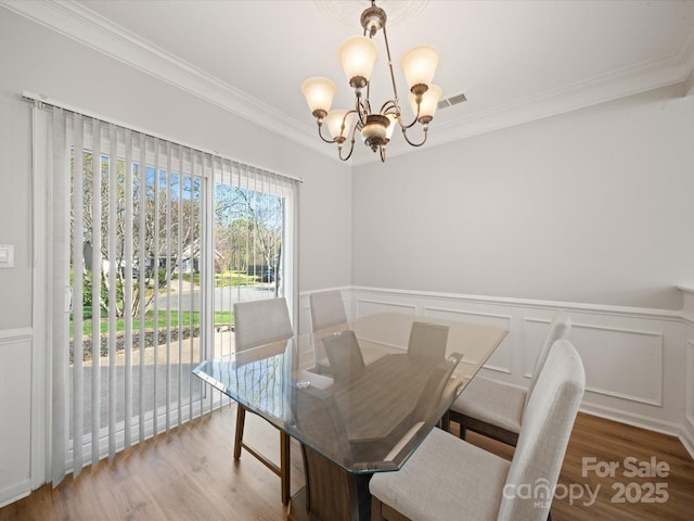 14802 Rolling Sky Dr, Charlotte, NC 28273 - dining room with a notable chandelier, visible vents, wood finished floors, and ornamental molding