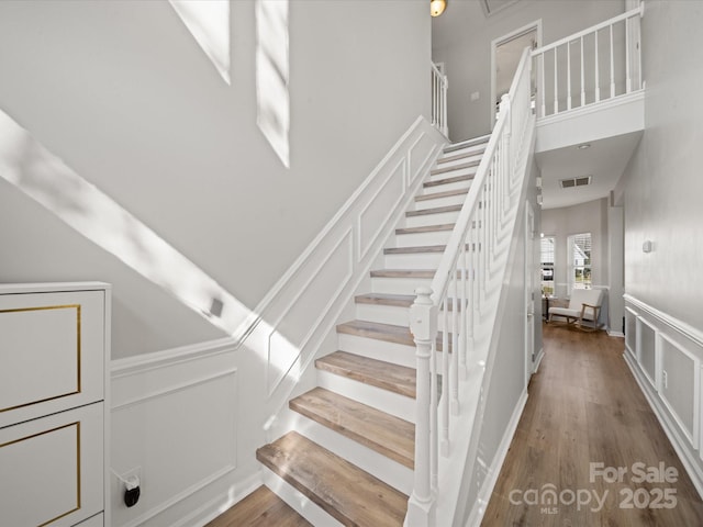 14802 Rolling Sky Dr, Charlotte, NC 28273 - stairs with visible vents, a decorative wall, wood finished floors, and a wainscoted wall