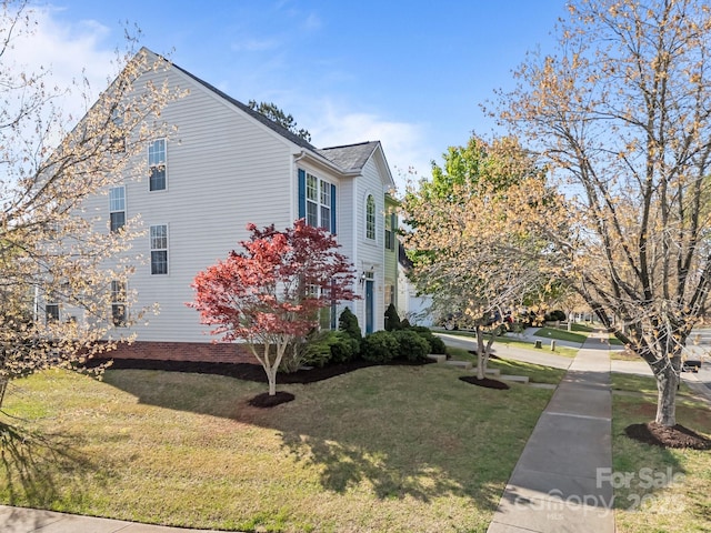 view of side of home with a lawn