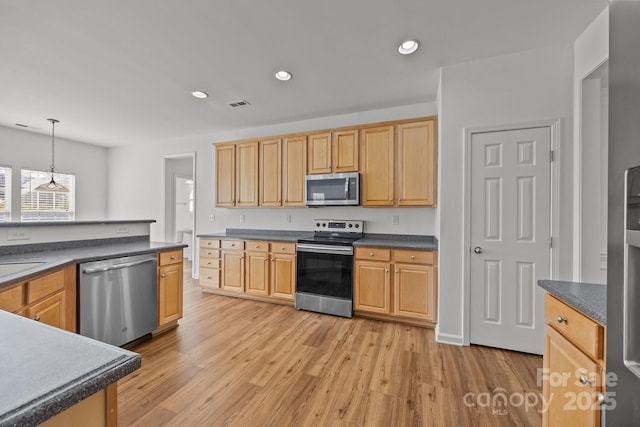 kitchen featuring visible vents, light wood finished floors, dark countertops, recessed lighting, and appliances with stainless steel finishes