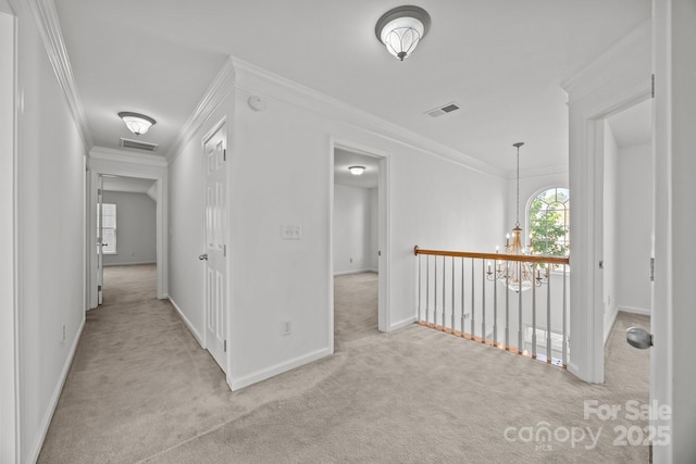 corridor featuring carpet floors, ornamental molding, baseboards, and visible vents