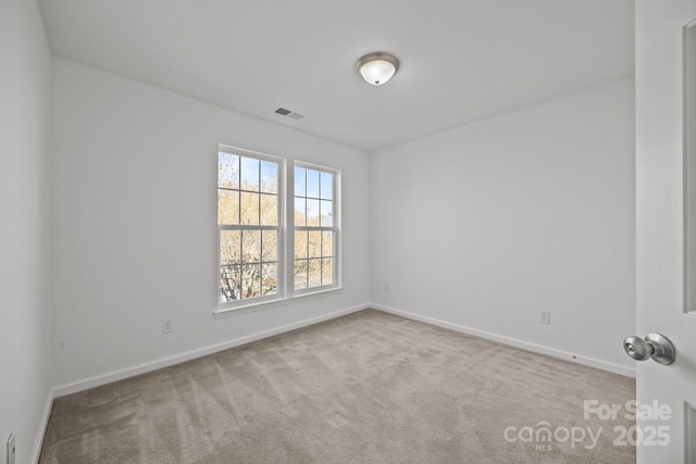 unfurnished room with baseboards, visible vents, and carpet flooring