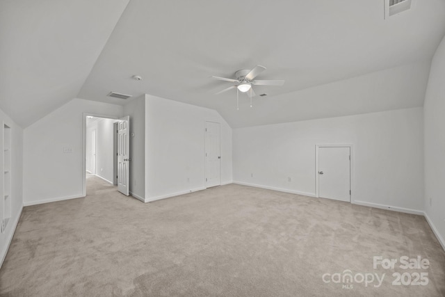 additional living space featuring visible vents, lofted ceiling, and ceiling fan