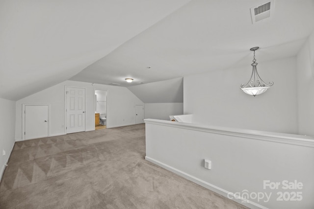 bonus room featuring visible vents, carpet, and vaulted ceiling