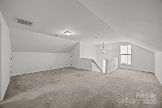 additional living space featuring visible vents, carpet, and vaulted ceiling