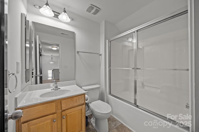 full bath with visible vents, toilet, bath / shower combo with glass door, and vanity