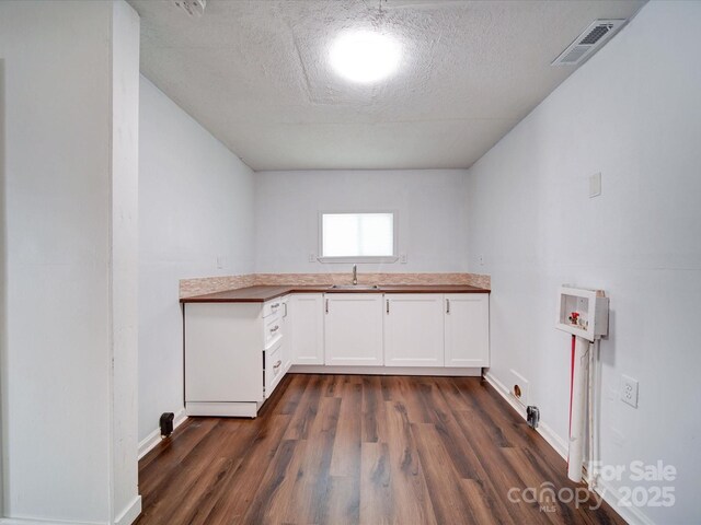 2300 Kennesaw Dr, Charlotte, NC 28216 - clothes washing area featuring visible vents, baseboards, and dark wood-type flooring