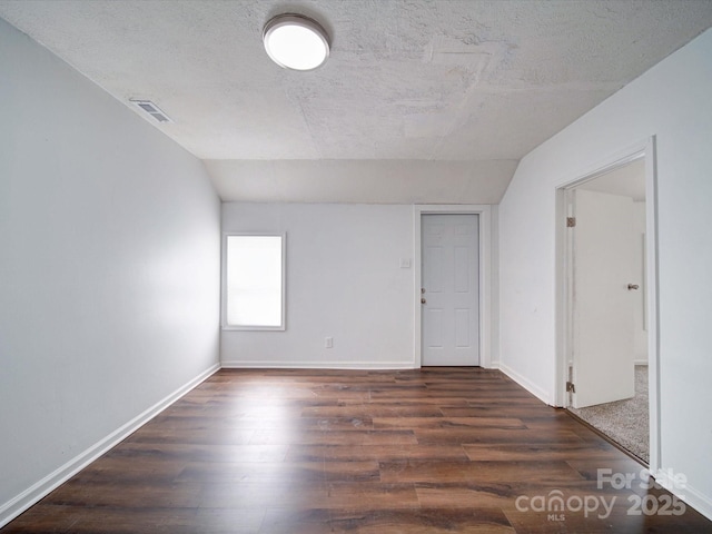 2300 Kennesaw Dr, Charlotte, NC 28216 - empty room featuring visible vents, dark wood-style flooring, baseboards, and vaulted ceiling