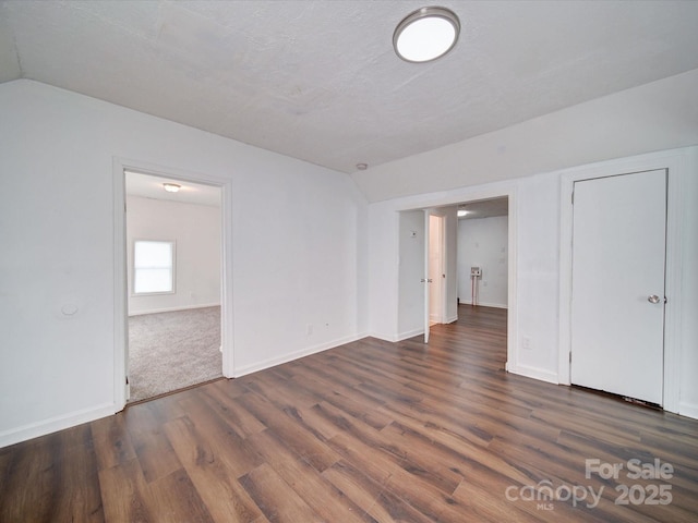 2300 Kennesaw Dr, Charlotte, NC 28216 - interior space with baseboards, vaulted ceiling, and dark wood-type flooring
