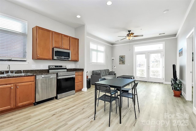 kitchen featuring ceiling fan, a sink, brown cabinets, and appliances with stainless steel finishes