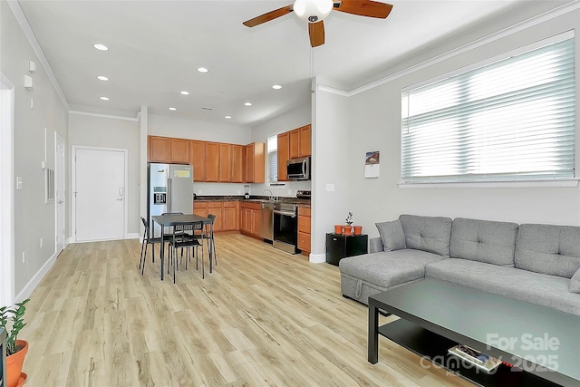 living room with a ceiling fan, crown molding, light wood finished floors, and recessed lighting
