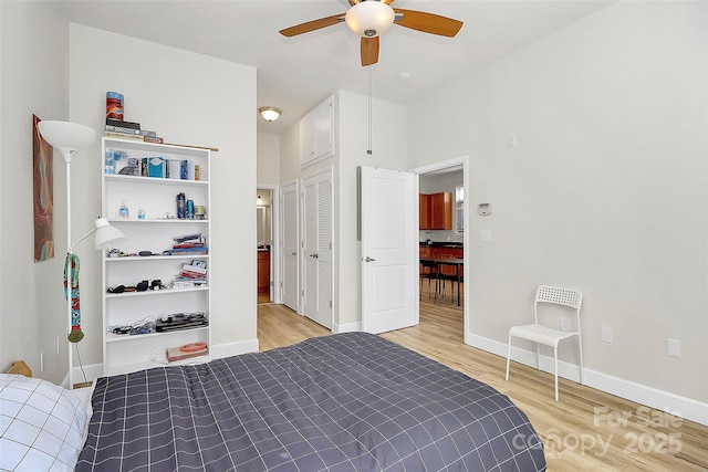 bedroom featuring baseboards, a closet, light wood-style floors, and ceiling fan