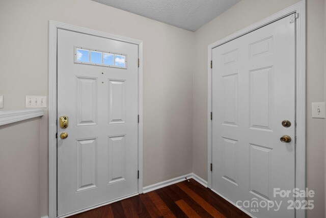 11929 Kings Castle Ct, Charlotte, NC 28277 - entryway featuring a textured ceiling, dark wood-style floors, and baseboards