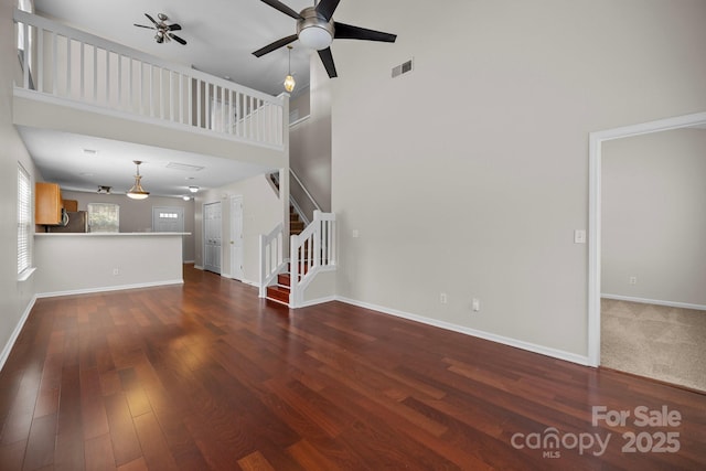 11929 Kings Castle Ct, Charlotte, NC 28277 - unfurnished living room with wood finished floors, stairway, ceiling fan, and visible vents