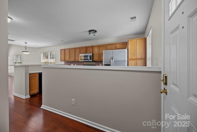 11929 Kings Castle Ct, Charlotte, NC 28277 - kitchen with dark wood-style floors, visible vents, a peninsula, and stainless steel appliances
