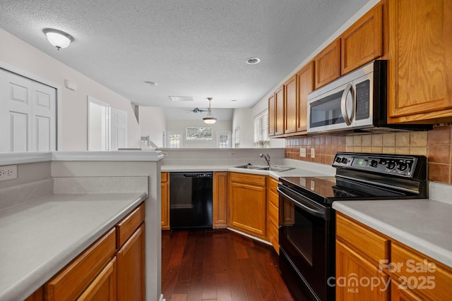 11929 Kings Castle Ct, Charlotte, NC 28277 - kitchen with dark wood-style floors, a sink, brown cabinetry, and black appliances