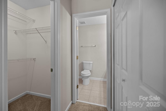 11929 Kings Castle Ct, Charlotte, NC 28277 - bathroom featuring toilet, a walk in closet, tile patterned flooring, baseboards, and visible vents